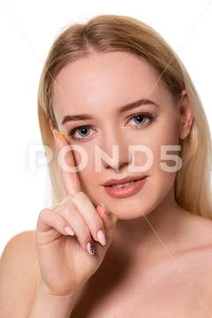 Young woman holding contact lens on index finger with copy space. Close up face Stock Photos