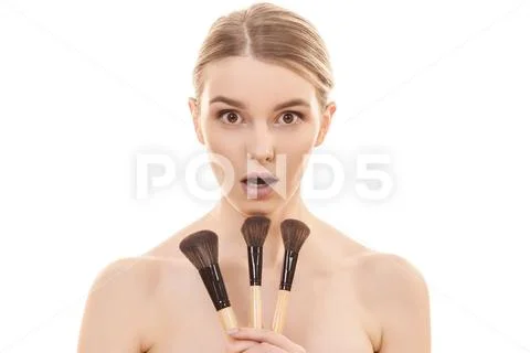 The young woman holding cosmetic brushes on the white background Stock Photos