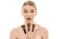 The young woman holding cosmetic brushes on the white background Photo