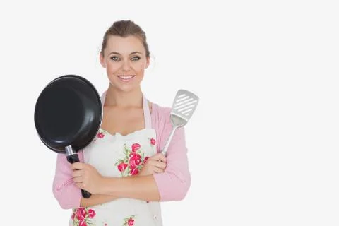 Young woman holding frying pan and spatula Stock Photos