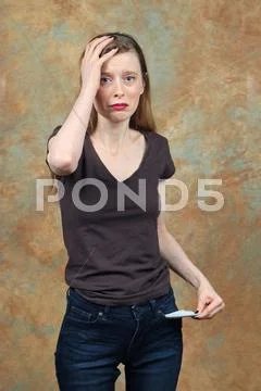 Young woman holding her head in desperation over poverty Stock Photos