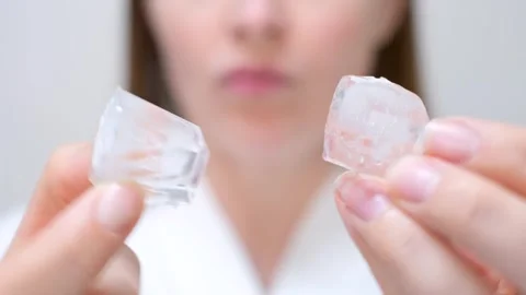 Young woman holding ice cube on face background, skin care concept. Stock Footage 321119853