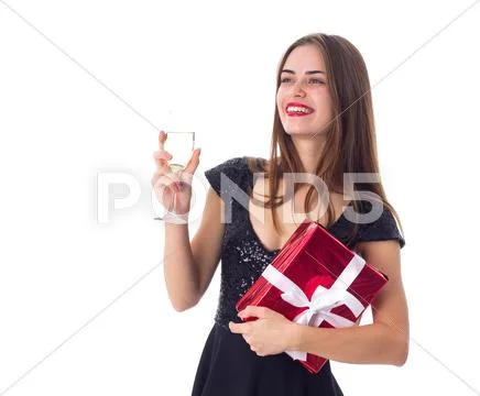 Young woman holding a present and a glass of champagne Stock Photos