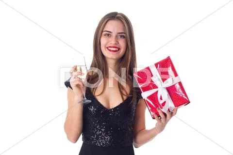 Young woman holding a present and a glass of champagne Stock Photos