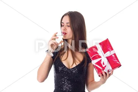 Young woman holding a present and drinking champagne Stock Photos