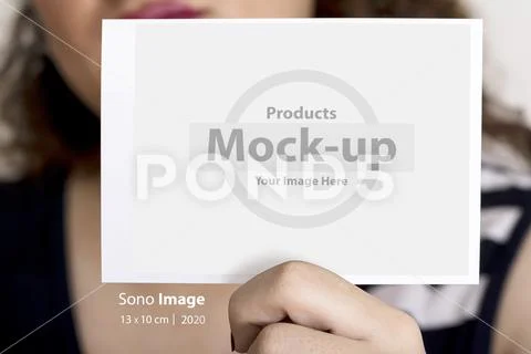 Young woman holding an sonography image in hand in front of her face mock-up PSD Template