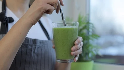 Young woman holding vegetable smoothie in glass Stock Footage 102617853
