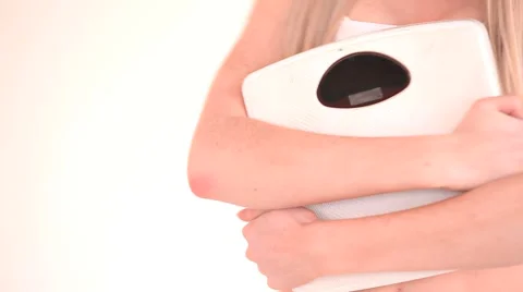 Young woman hugging her weighing scales Stock Footage