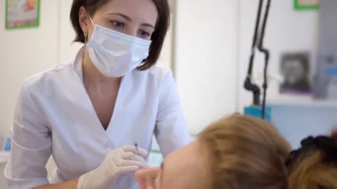 Young woman injected with botulin into skin of face. rejuvenating procedure in Stock Footage