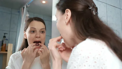 Young woman is inserting aligners on down teeth for correcting jaw joints. Stock Footage 158396739