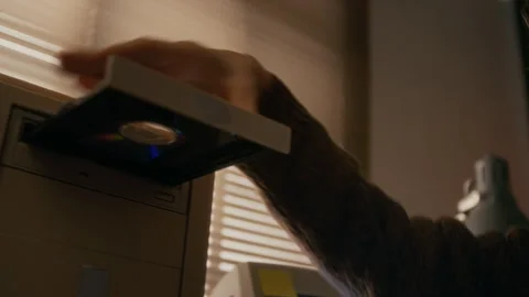 Young Woman Inserting CD into Disk Drive while Working on Vintage Computer Stock Footage 327238945