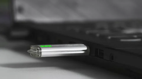 Young woman inserts a flash drive into a usb port into a computer on table Stock Footage 245712151