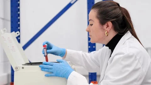 Young woman introducing samples in machine Vídeo Stock 255196127