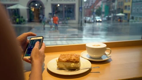 Young woman on iPhone smartphone while eating dessert at cafe restaurant Stock Footage 122173136