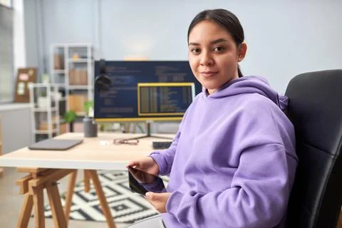 Young woman as IT programmer looking at camera at workplace Stock Photos