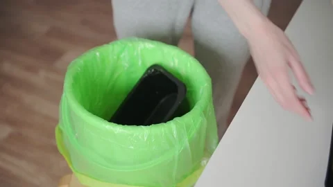 Young woman in kitchen throws plastic containers from food into garbage bag. Stock Footage 153511255