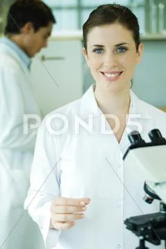 Young Woman In Laboratory, Holding Microscope Slide, Portrait