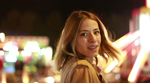 Young woman laughing and waving at camera in amusement park Stock Footage 59556301