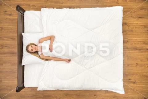 The young woman lay on the bed and smile. View from above Stock Photos
