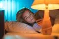 The young woman lay on the bed and phone. Evening night time Photo