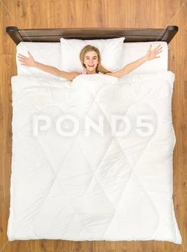 The young woman lay on the bed and gesture. View from above Stock Photos