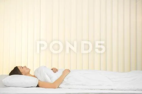 The young woman lay on the bed and smile Stock Photos