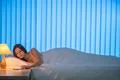 The young woman lay on the bed and phone. Evening night time Photo