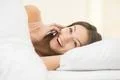 The young woman lay on the bed and phone Photo