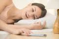 The young woman lay on the bed with phone Photo