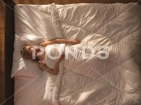 The young woman lay on the bed. View from above Stock Photos