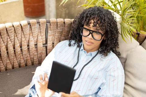 Young woman laying down while reading with an e-book Stock Photos
