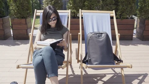 Young woman leafing through notebook looking for something outdoors Stock Footage 110250532