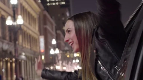 Young Woman Leans Out Car Window, At Red Light, She Dances, Puts Her Arms In Air Stock Footage