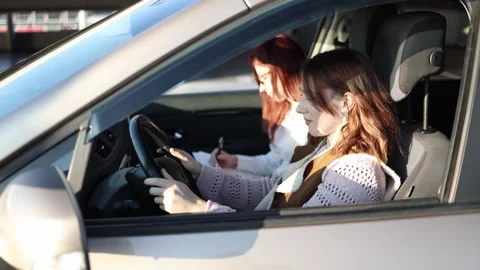Young woman learning to drive with instructor calm lesson Video stock 332872175