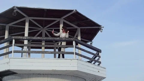 The young woman at the lighthouse. developing hair.slow motion Видео 75390120