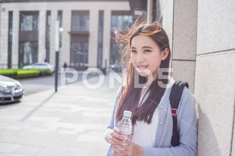 Young Woman Listen Music With Bottle Of Water In Hands