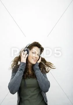 Young Woman Listening To Headphones, White Background