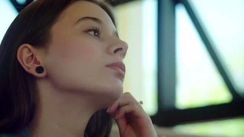 Young woman listening to music on headphones in a cafe Stock Footage