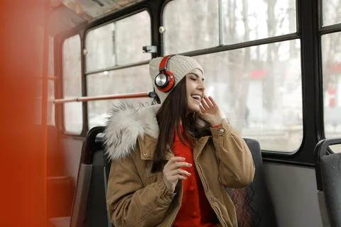 Young woman listening to music with headphones in public transport Stock Photos