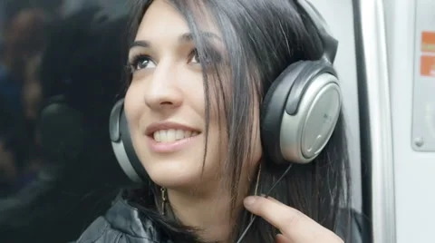 Young woman listening music on the metro train: underground, subway Stock Footage