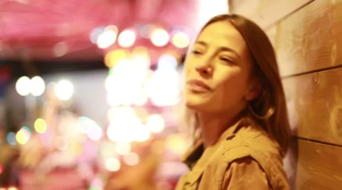 Young woman looking at camera and laughing in amusement park Stock Footage 59556277