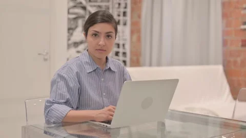 Young Woman Looking at Camera while Working on Laptop Video stock 238647723