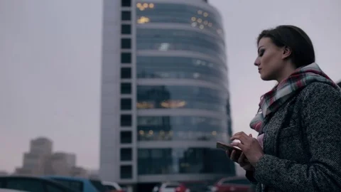 Young woman looking down to smart phone in downtown Stock Footage