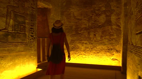 A young woman looking at the hieroglyphs inside the temple of Abu Simbel Stock Footage 142157152