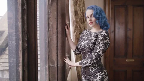 Young woman looking through a window in a lace dress Stock Footage 109488305