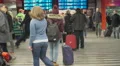 Young woman looking at train schedule in waiting area, tourism. Slow-motion HD Footage