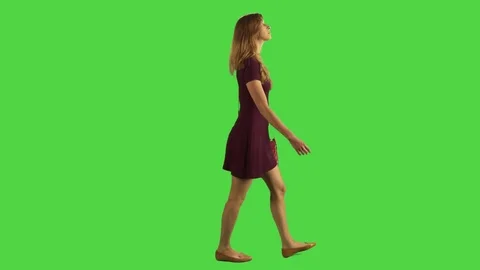A young woman looking upward while walking over a green screen. Stock Footage