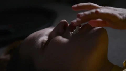 Young woman lying and stuffing her mouth with large amounts of popcorn Vídeo Stock 336900510