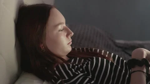 Young woman lying on bed using tablet in dark room Stock Footage 310924962