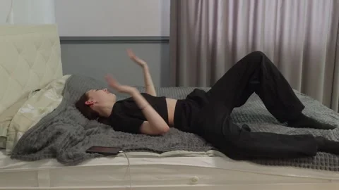 Young woman lying on bed using smartphone at home, relaxed lifestyle Video stock 326611518